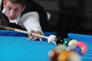 jeune homme joue au jeu de billard pro photo