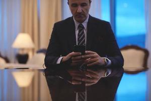 homme d'affaires utilisant un téléphone intelligent au bureau de luxe photo