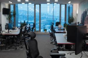 vue de face de l'intérieur du bureau de coworking avec lieux de travail, cadre photo vierge sur le mur et l'ordinateur.