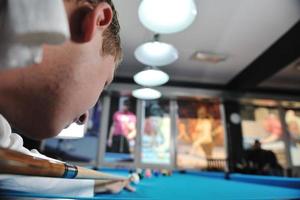 jeune homme joue au jeu de billard pro photo