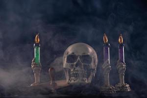 crâne humain halloween sur une vieille table en bois sur fond noir. forme d'os du crâne pour la tête de mort sur le festival d'halloween qui montre l'horreur de la fumée de la bougie maléfique peur et effrayant, espace de copie