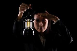 une femme d'affaires tient une lanterne de lampe lumineuse comme un moyen de sortir du problème, la créativité de la solution de l'idée inspire le succès de l'innovation qui brille dans votre invention d'imagination. sortie de vision de concept, espace de copie photo