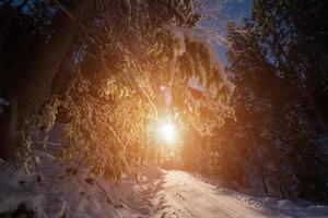 route de campagne enneigée au coucher ou au lever du soleil photo