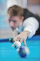 jeune homme joue au jeu de billard pro photo