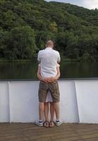 un couple se tenant fermement sur un bateau fluvial photo