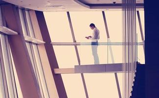 jeune homme d'affaires prospère dans un appartement penthouse travaillant sur tbalet photo