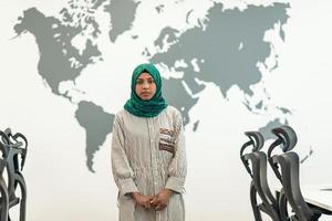 portrait de femme musulmane développeur de logiciels avec hijab vert debout au bureau de démarrage moderne à plan ouvert photo