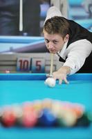 jeune homme joue au jeu de billard pro photo