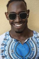 portrait d'un jeune homme africain souriant portant des vêtements traditionnels photo