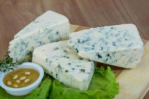 Fromage bleu sur planche de bois et fond de bois photo