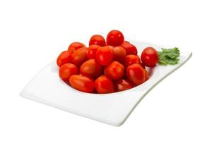 tomates cerises dans un bol sur fond blanc photo