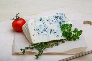 Fromage bleu sur planche de bois et fond de bois photo