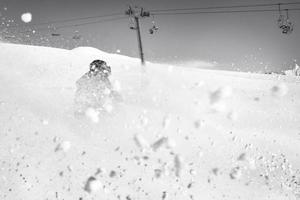 image dynamique d'un skieur sur la piste dans les alpes. skieuse dans la neige molle. vacances d'hiver actives, ski alpin par beau temps. promenades à ski sur la piste avec des tourbillons de neige fraîche photo