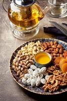 assortiment de noix et de fruits secs de style oriental sur un plateau - abricots secs, noix de cajou, pistaches, amandes et noix photo