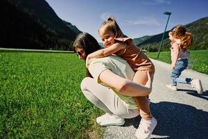 mère tient un enfant sur ses épaules dans une prairie alpine à untertauern, autriche. photo