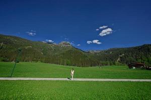 femme debout sur le chemin dans la prairie alpine à untertauern, autriche. photo