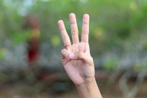 montrant des nombres en utilisant la langue des signes avec des mains féminines en arrière-plan isolé photo