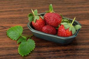 Fraise fraîche dans un bol sur fond de bois photo