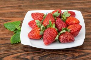 fraise fraîche sur la plaque et le fond en bois photo