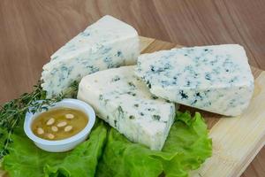 Fromage bleu sur planche de bois et fond de bois photo