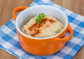 Houmous dans un bol sur fond de bois photo