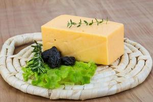 Fromage jaune sur planche de bois et fond de bois photo