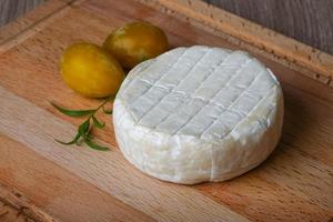 Fromage brie sur planche de bois et fond de bois photo