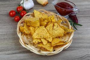 nachos dans un panier sur fond de bois photo