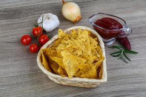 nachos dans un panier sur fond de bois photo