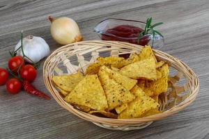 nachos dans un panier sur fond de bois photo