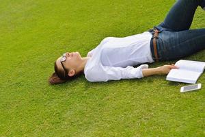 jeune femme lisant un livre dans le parc photo