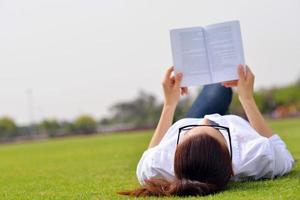 jeune femme lisant un livre dans le parc photo