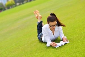 jeune femme lisant un livre dans le parc photo