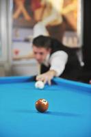 jeune homme joue au jeu de billard pro photo