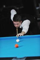 jeune homme joue au jeu de billard pro photo