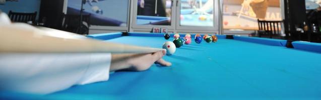 jeune homme joue au jeu de billard pro photo