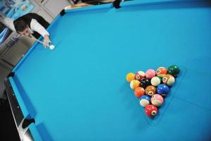 jeune homme joue au jeu de billard pro photo