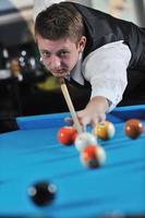 jeune homme joue au jeu de billard pro photo