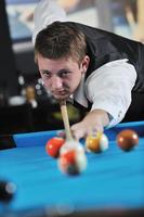 jeune homme joue au jeu de billard pro photo