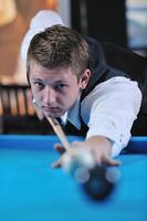 jeune homme joue au jeu de billard pro photo