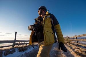 jeune photographe marchant sur une route de campagne photo