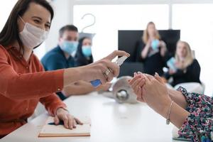 nouveaux hommes d'affaires normaux lors d'une réunion à l'aide d'un désinfectant antibactérien pour les mains photo