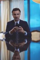 homme d'affaires utilisant un téléphone intelligent au bureau de luxe photo