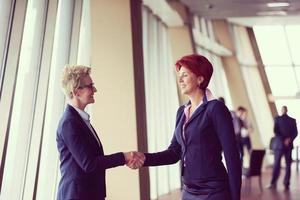 les femmes d'affaires font un accord et une poignée de main photo