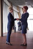 les femmes d'affaires font un accord et une poignée de main photo