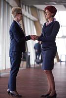 les femmes d'affaires font un accord et une poignée de main photo