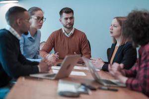 équipe performante. groupe de jeunes hommes d'affaires multiethniques travaillant et communiquant ensemble dans un bureau créatif. mise au point sélective photo