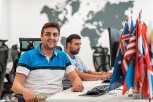 groupe d'hommes d'affaires occasionnels travaillant sur un ordinateur de bureau dans un intérieur de bureau de démarrage à plan ouvert moderne. mise au point sélective photo