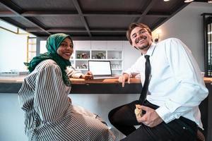 équipe d'affaires multiculturelle internationale.un jeune homme et femme d'affaires s'assoient dans un espace de détente moderne et parlent d'une nouvelle entreprise. photo