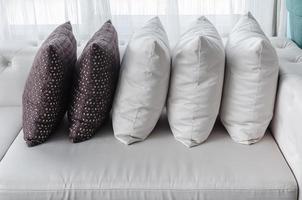 Rangée d'oreillers sur un canapé moderne blanc dans le salon photo